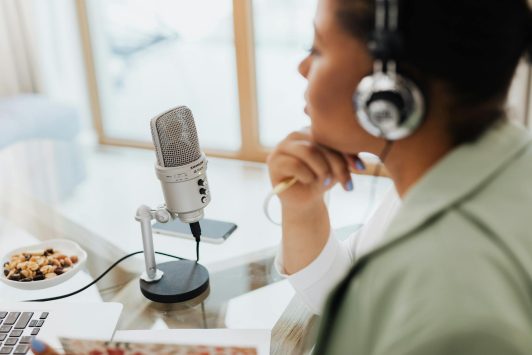 woman using headphones and microphone with laptop
